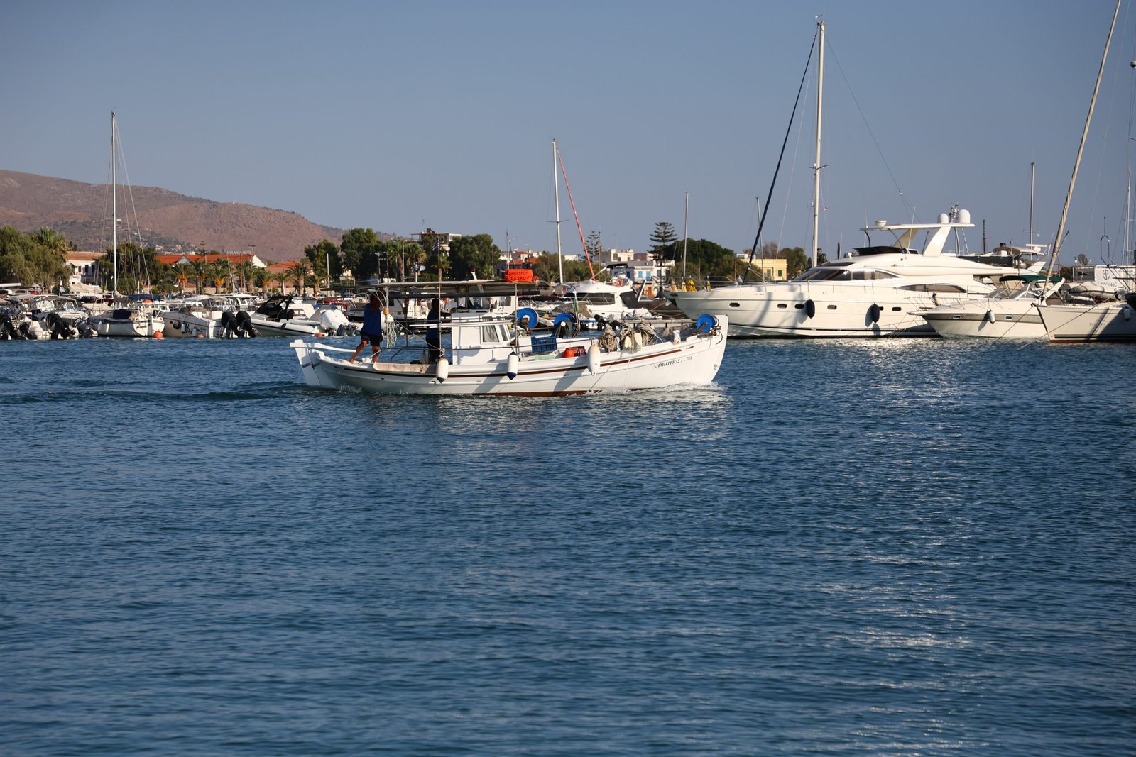 Fishing boat leaving the port A fishing boat going out of the port of Aegina